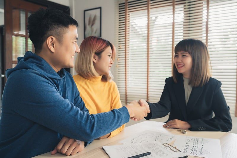 happy-young-asian-couple-shaking-hands-with-banking-representative